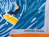 serviette sur laquelle est représenté un surfeur chevauchant une vague sur une planche de surf