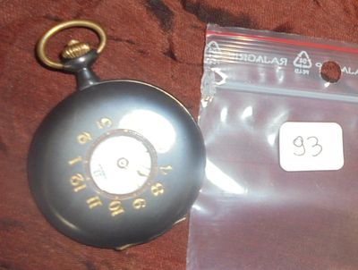 une montre de poche et une étiquette attachée à un morceau de tissu marron