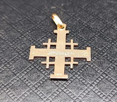 gros plan d'une croix en or sur une surface noire