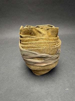 a close up of a small bowl with a cloth wrapped around it