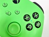 a close up of a green controller on a white surface