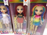 three dolls of different colors are in a box on a white surface