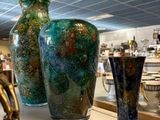 three vases sitting on a shelf in a store