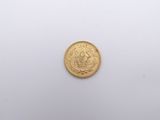 a close up of a gold coin on a white surface