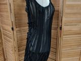 a black dress on a mannequin stand in front of shutters