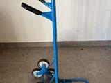 a blue hand truck that is sitting on the floor