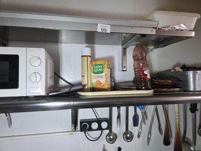 une étagère avec un micro-ondes, un four à micro-ondes et d'autres ustensiles de cuisine