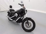 une moto noire garée dans une pièce aux murs blancs