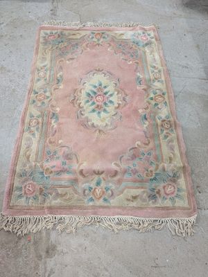 un vieux tapis posé par terre devant un immeuble