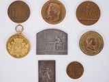 an image of a collection of coins and a medal on a white surface
