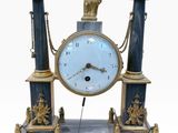 a blue and gold clock with a statue on top of it
