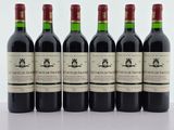 six bouteilles de vin rouge alignées sur une table