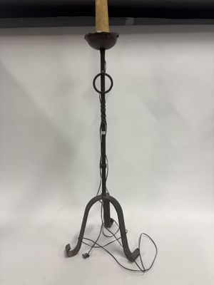 un grand bougeoir en métal surmonté d'une bougie