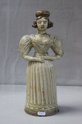 une statue représentant une femme en robe, posée sur une table