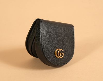 a black leather wallet case with a gold gg logo on the front