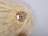 a person holding a piece of hair with a button on it