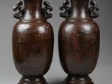 two brown vases sitting on top of each other on a gray surface