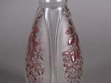 a glass vase that has a pink design on it