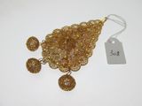 un gros plan d'un collier et de boucles d'oreilles en or posés sur une surface blanche