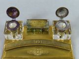 a gold desk set with a mirror and a pen and inkwell