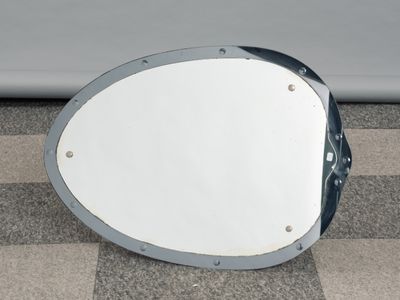 a mirror sitting on the ground next to a car
