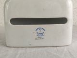 a white paper towel dispenser on a table