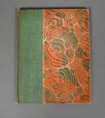 an orange and green book sitting on top of a gray table