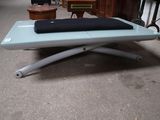 une table basse en verre sur laquelle est posé un coussin noir