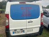 a van that is parked in the grass near other cars