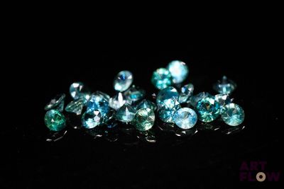 some very pretty blue and green diamonds on a black surface