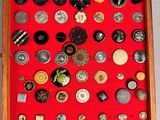 a picture of a display of buttons in a wooden frame