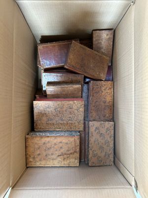 a cardboard box full of old books in it