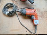 a drill and a cord on a table with other tools