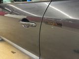 a silver car with a hole in the side door
