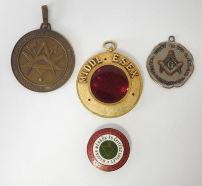 trois médailles et une médaille sont posées sur une surface blanche