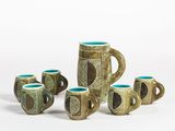 five mugs sitting next to each other on a white surface