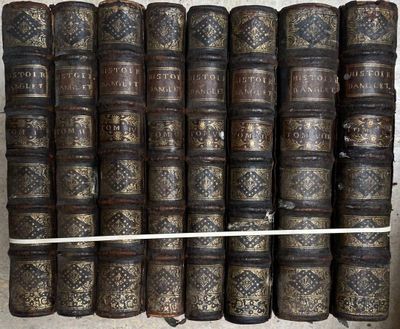 plusieurs vieux livres empilés les uns sur les autres sur une étagère