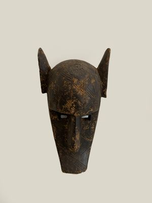 an image of a wooden mask with horns on a white background