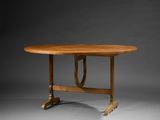 une table à manger ovale avec un plateau et un piètement en bois