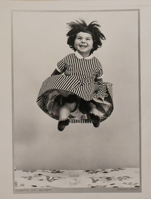 une vieille photo en noir et blanc d'une petite fille en train de sauter en l'air