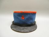 un chapeau bleu orné d'un écusson rouge et bleu