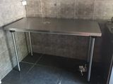 a stainless steel table in the corner of a kitchen