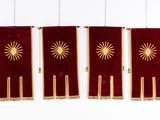 three red and gold banners hanging on a white wall