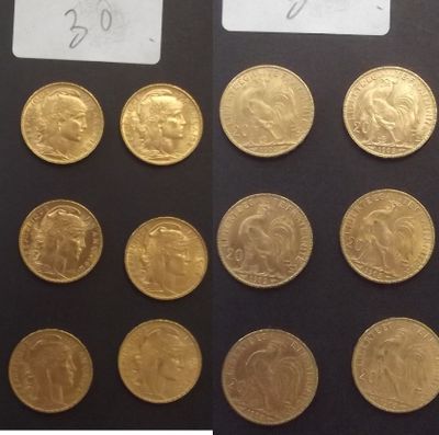 quelques pièces d'or sont posées sur une surface noire, accompagnées d'une étiquette indiquant leur prix