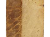 un vieux livre posé sur une surface blanche