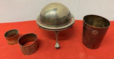 three cups and a silver plate on a red cloth