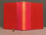 an open red book with a red cover sitting on top of a table