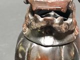 a small metal container with a dragon on top of it
