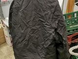black jacket hanging on a rack in a room with other items