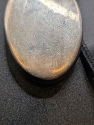 a close up of a pocket watch on a black cloth